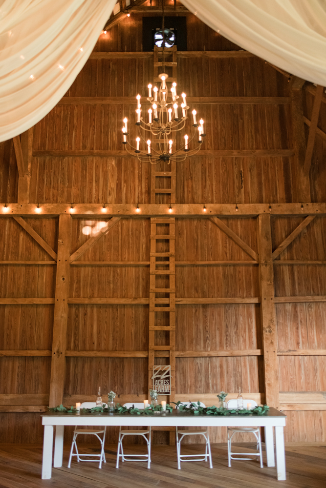 head table at a wedding inside a barn venue