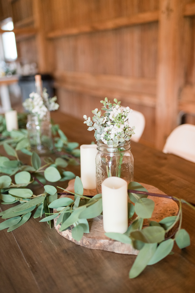 candles and greenery in a barn wedding venue
