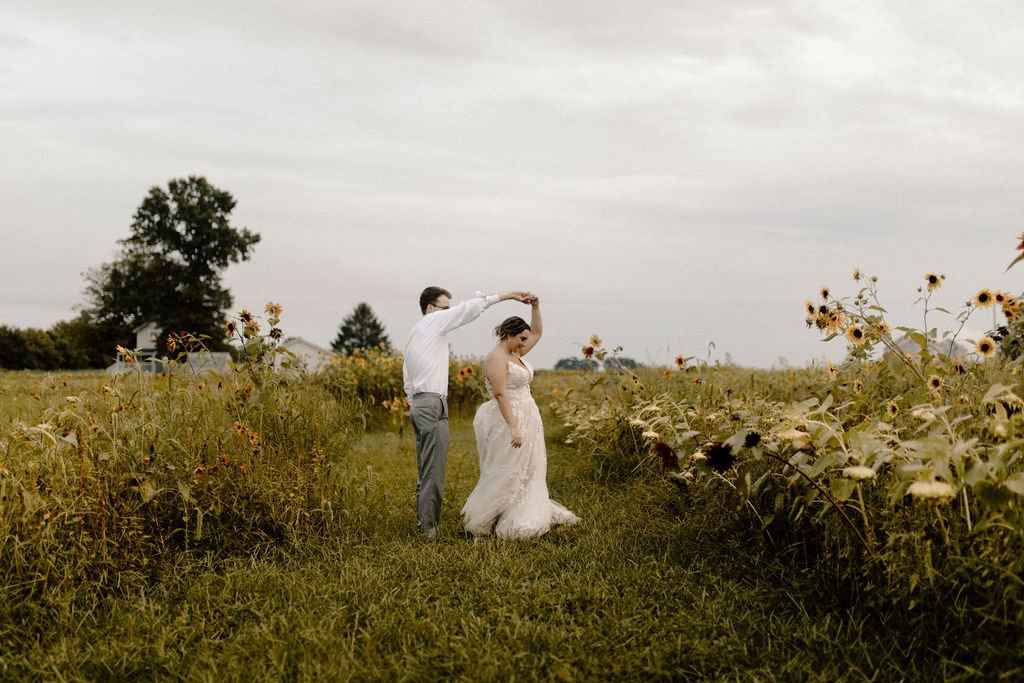 a bride and groom dancing in a sunflower field