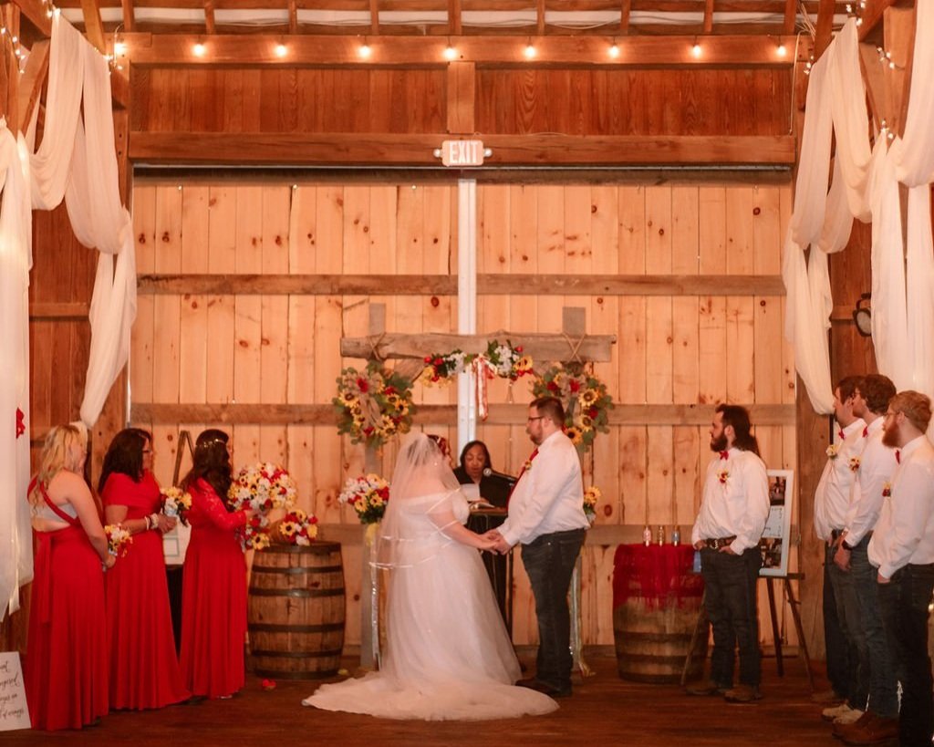 bride and groom exchange vows in their barn wedding ceremony
