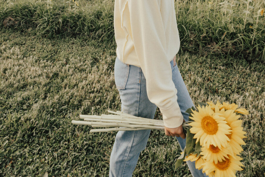 A person holding a bouquet of sunflowers