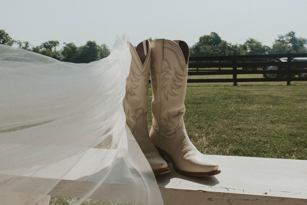 A bride's veil and cowboy boots at the 22 Acres Farm countryside venue outside Columbus, Ohio, 