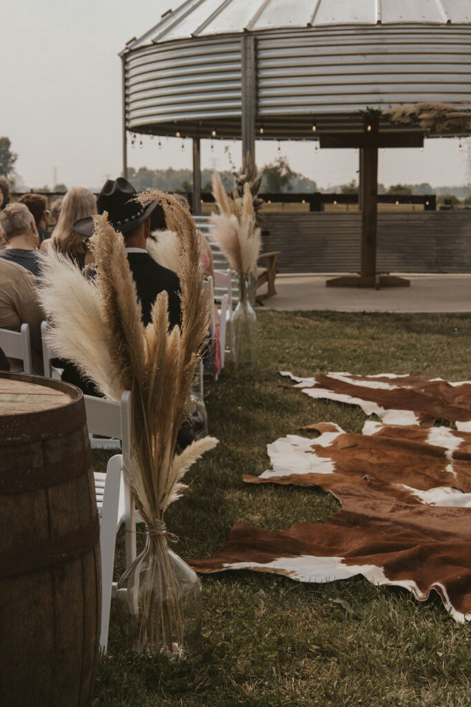 cow hide, neutral colors, a grain bin gazebo and cross background for a barnyard wedding at 22 Acres Farm outside Columbus, Ohio