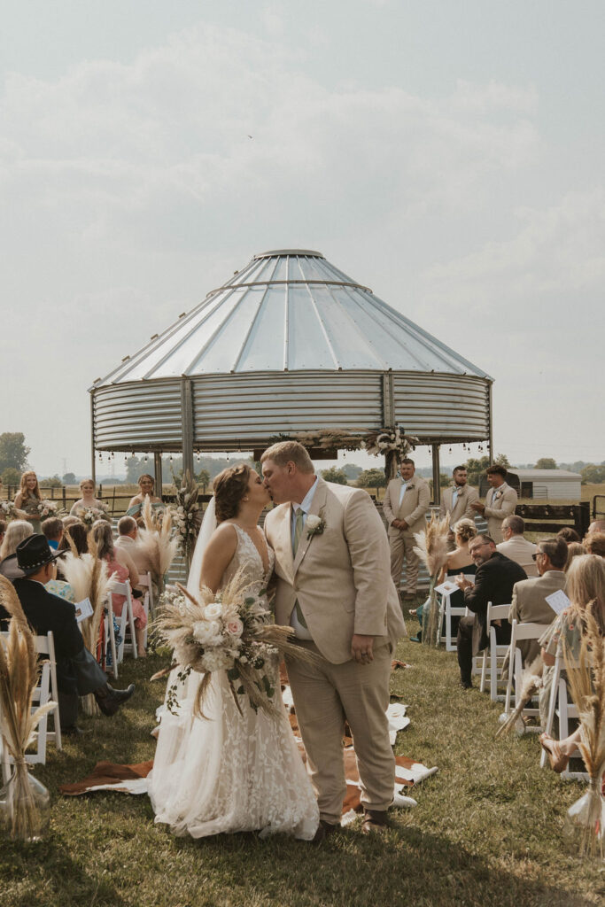A couple kissing after their wedding ceremony at 22 Acres Farm.