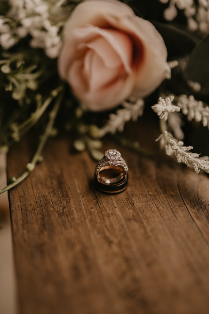 A wedding ring and bouquet of roses on the barn floor at 22 Acres Farm outside Columbus, Ohio.