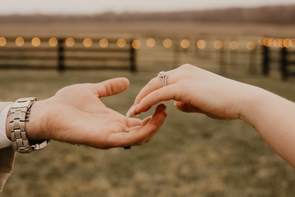 a bride and groom reaching for each other in the barnyard outside 22 Acres Farm and Venue near Columbus, Ohio.