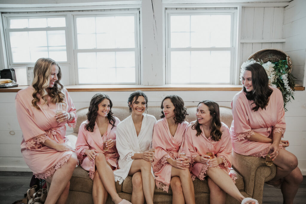 A bridal party sipping champagne in a rustic bridal suite at 22 Acres Farm.