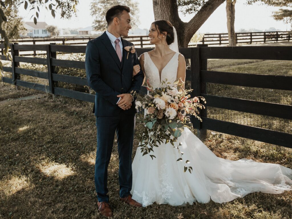 A bride and groom in the Ohio countryside following their fall barn wedding.