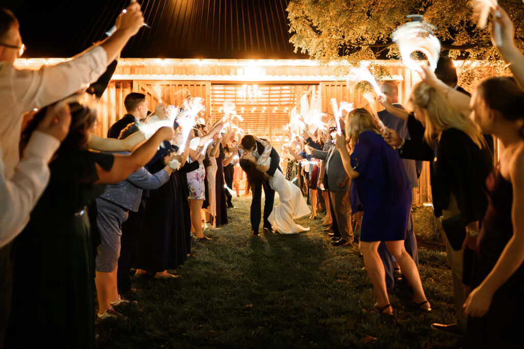 Wedding couple exiting surrounded by celebration lights at 22 Acres Farm, a wedding venue in Columbus, Ohio.