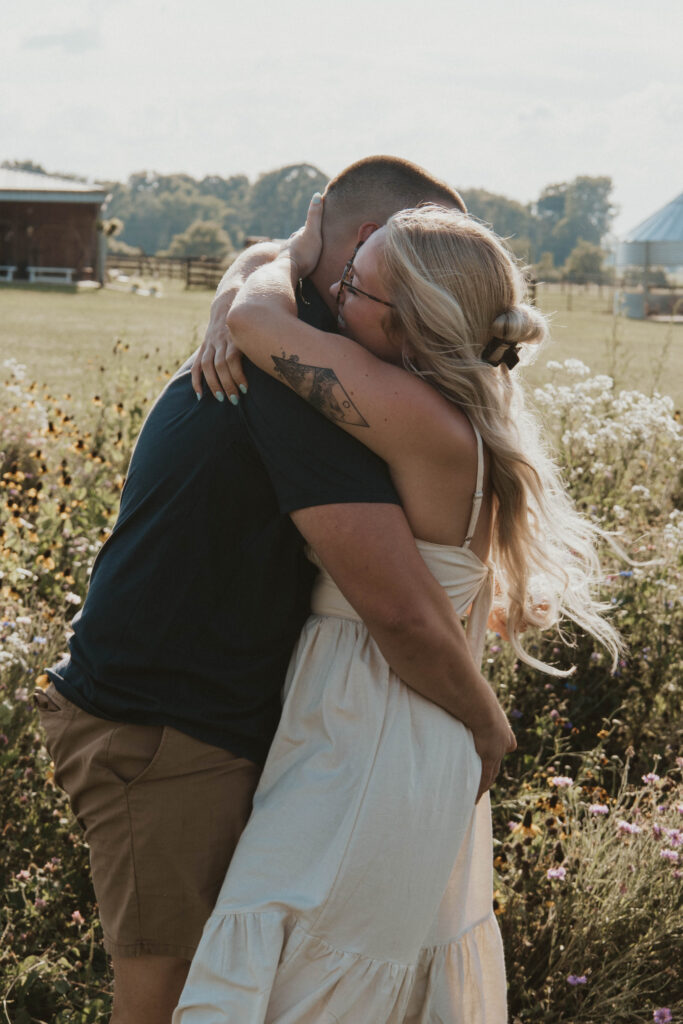 A couple celebrating their engagement with a joyful dance in a Newark, Ohio wildflower field.