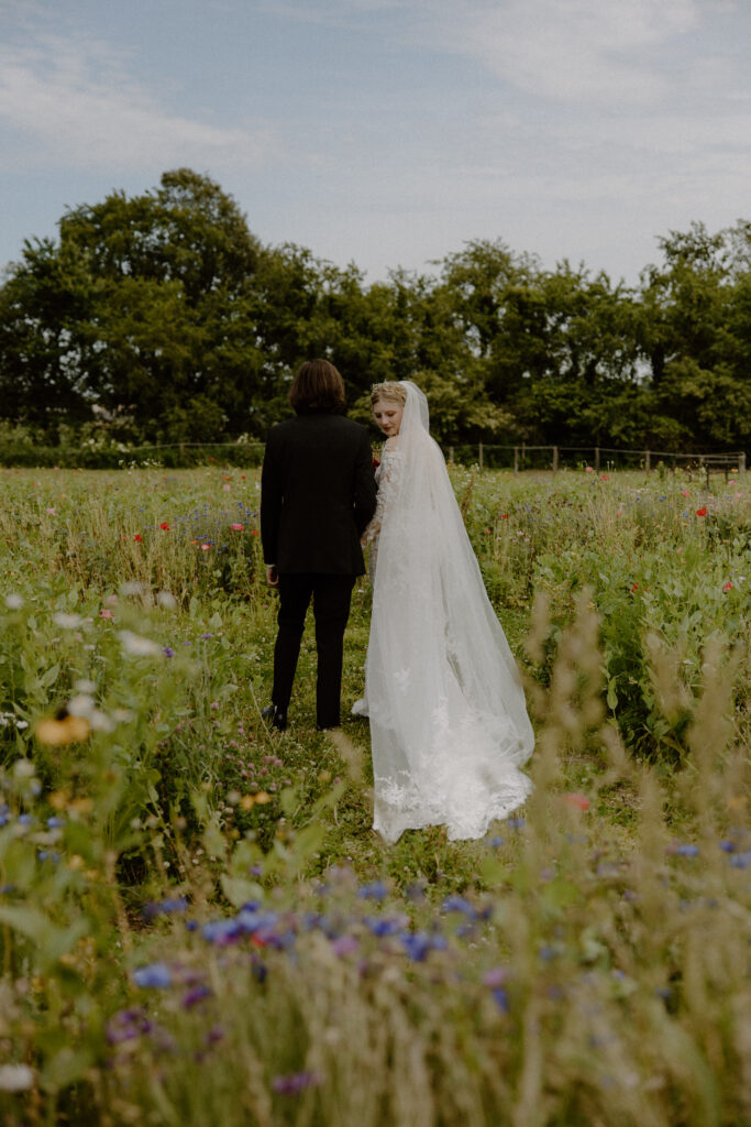 A bride and groom walking through the wildflower fields at 22 Acres Farm outside Columbus, Ohio.