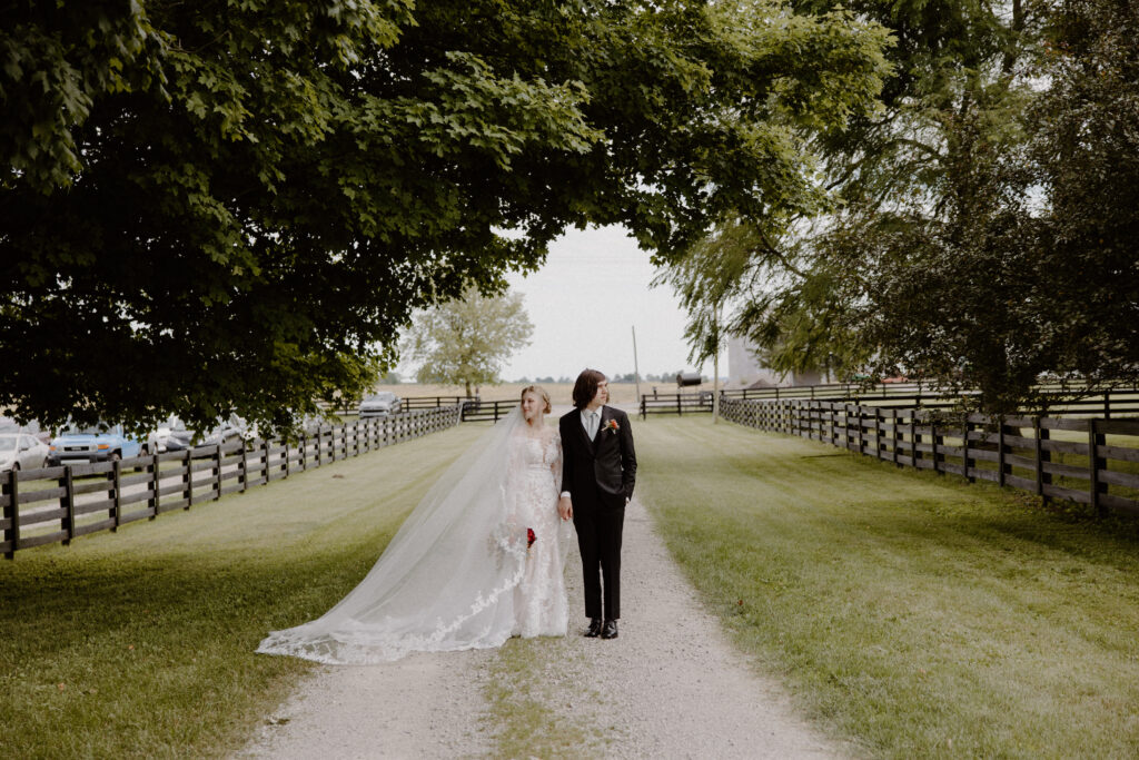 A bride and groom walking down a tree-covered path at their Columbus, Ohio wedding last June.