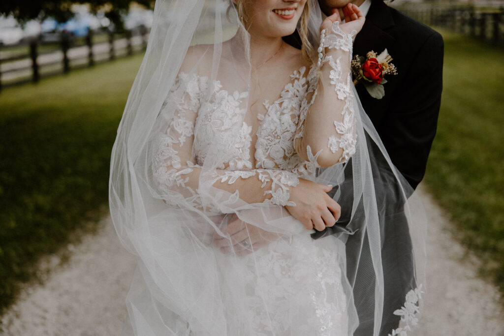 A bride and groom embracing in the expansive fields surrounding 22 Acres Farm, a wedding venue outside Columbus, Ohio.