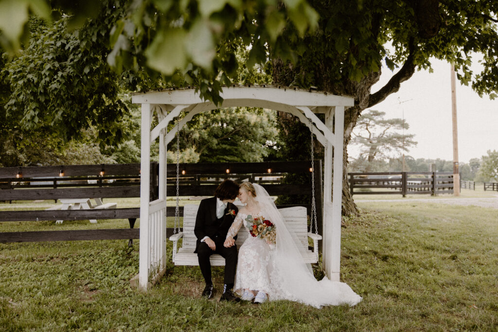 A bride and groom embracing on a wooden swing at 22 Acres Farm and wedding venue near Columbus, Ohio