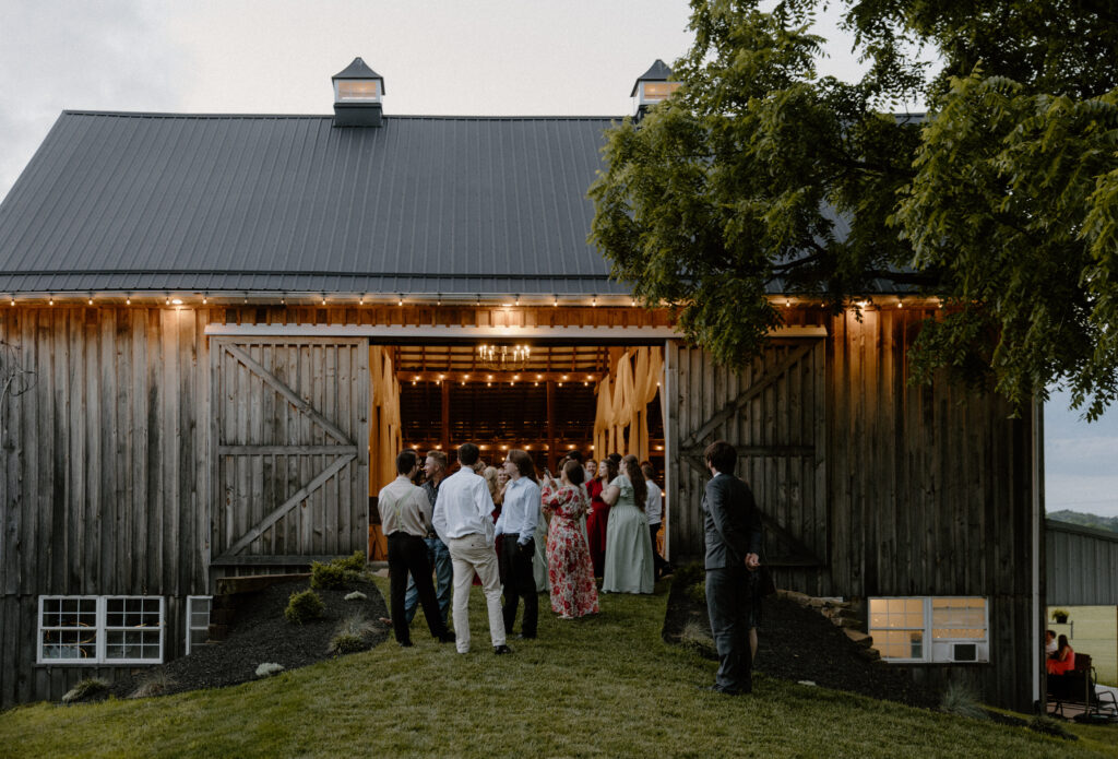 Guests mingling in and around the Barn at 22 Acres Farm, a Columbus, Ohio wedding venue.