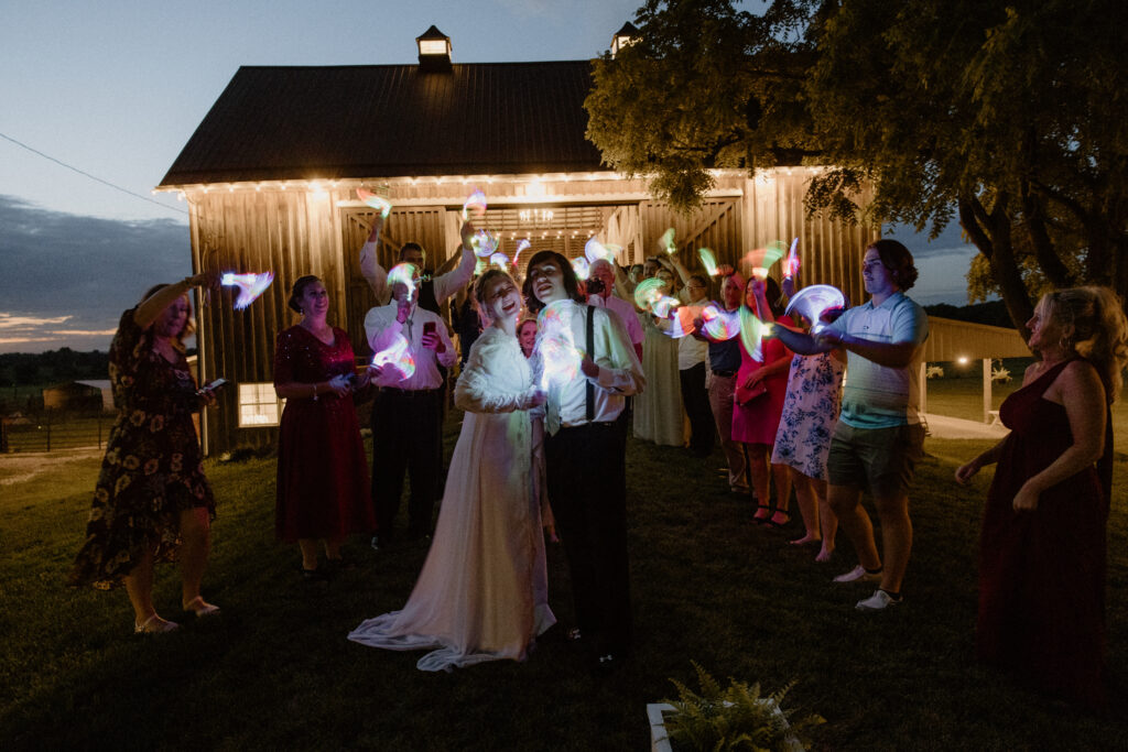 Wedding guests seeing off the bride and groom with glow sticks at their charming Columbus, Ohio wedding last June.